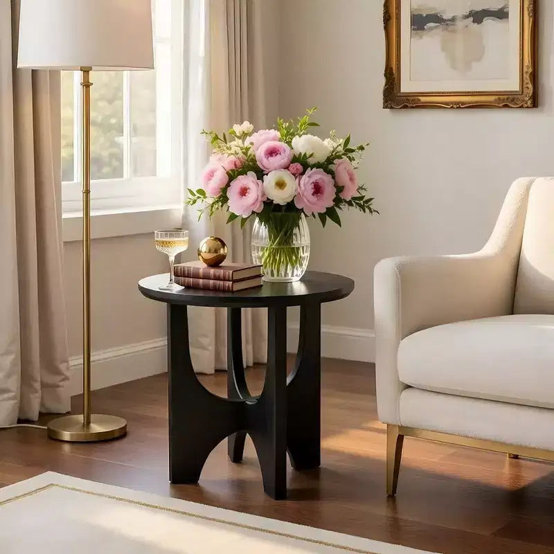 Round side table/coffee table featuring a 20-inch matte black solid mango wood tabletop and curved legs.