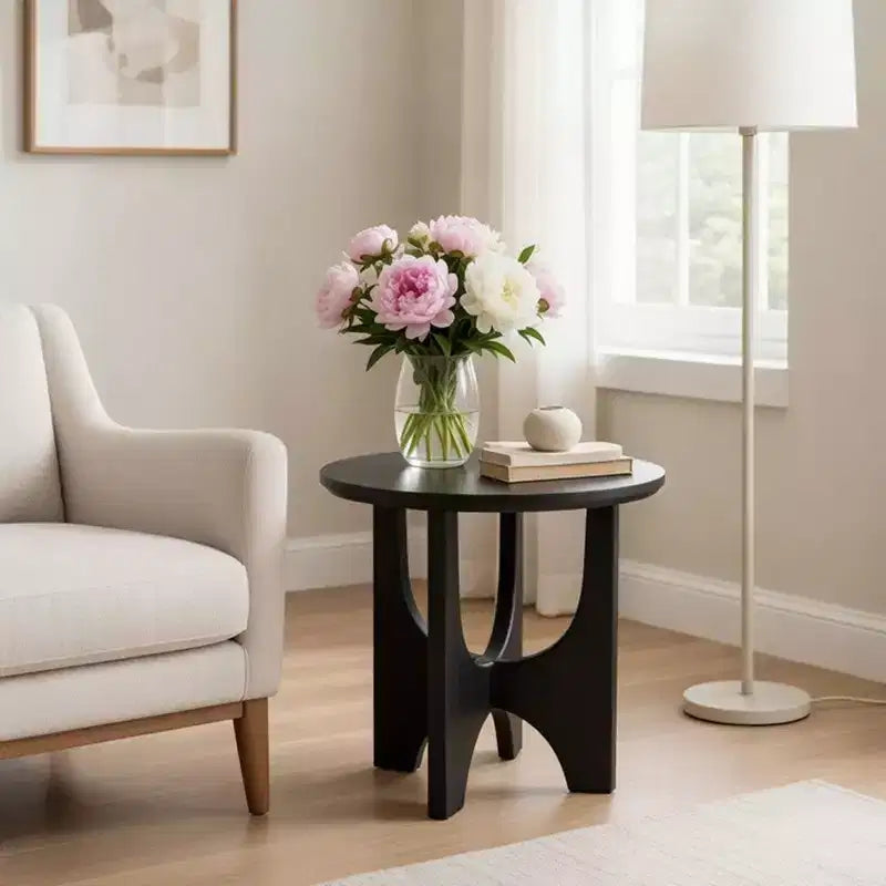 Round side table/coffee table featuring a 20-inch matte black solid mango wood tabletop and curved legs.